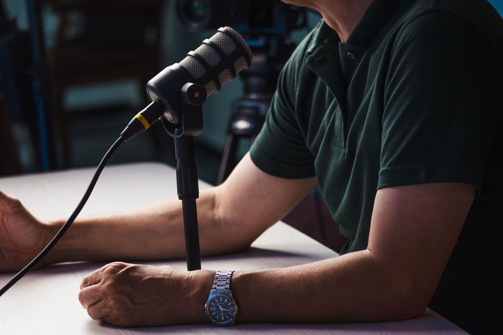 Person spricht in einem Studio in ein Podcast-Mikrofon